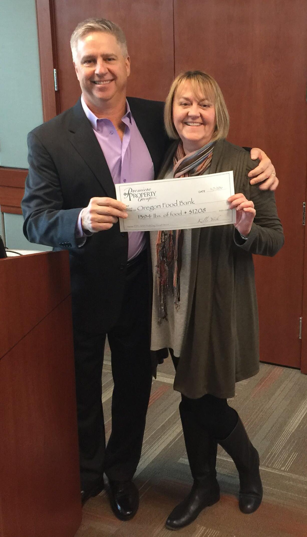 Clark County: Premiere Property Group President Kelly Yock, left, Diane Peterson, Premiere broker, with a $1,208 check raised for the Oregon Food Bank during a holiday drive, which Peterson led.