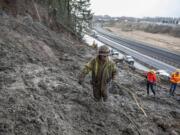 Jon Simpson of Access Limited Construction navigates through thick mud while working along the side of Interstate 5 on Friday morning near Woodland.