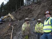 Jon Simpson, from left, Joe Milos and Joe Colbert of Access Limited Construction talk as they work along the side of I-5 on Jan.