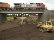 Construction continues clearing a passageway to the Columbia River waterfront through the BNSF Railway berm at the south end of Esther Street on Wednesday.