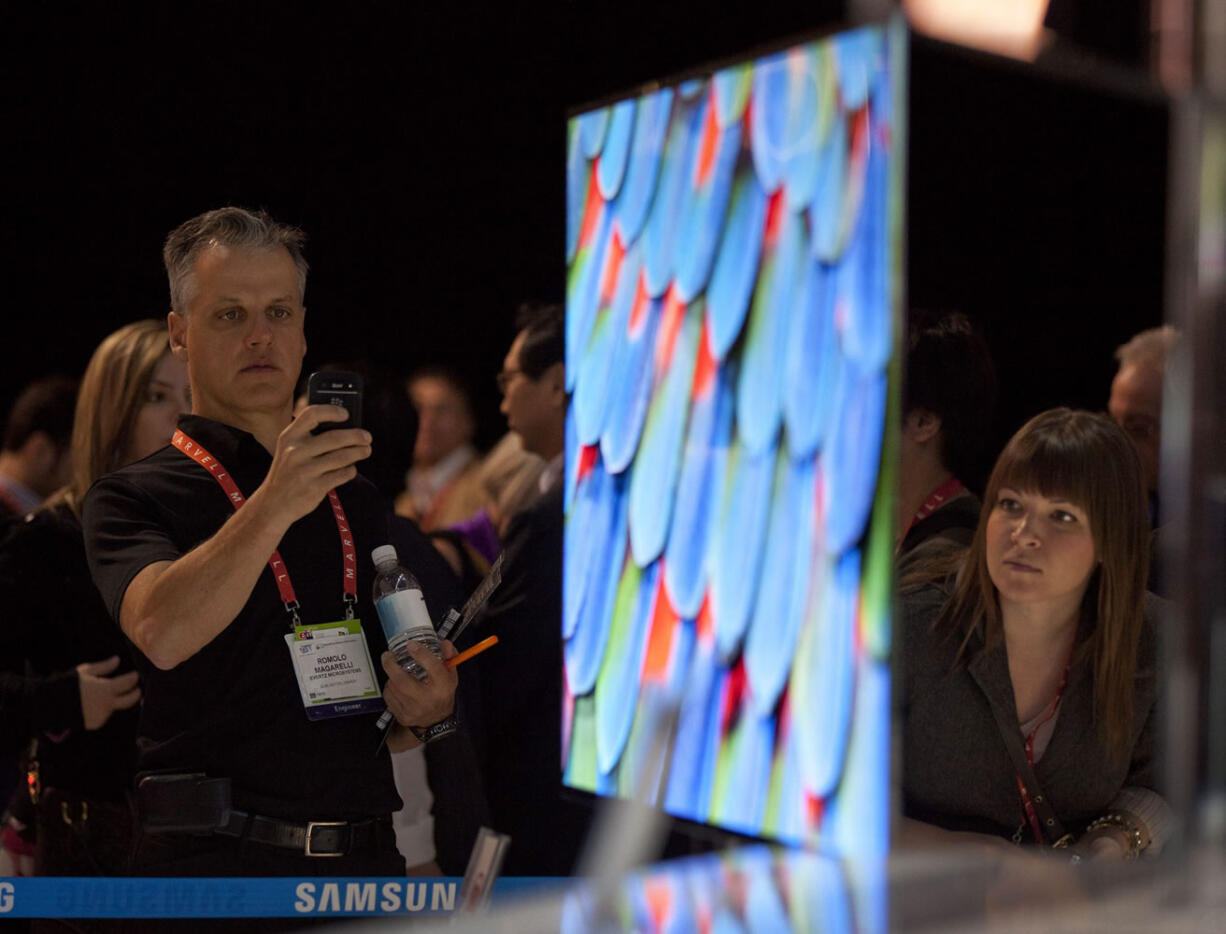 Industry affiliates examine the new Samsung 55-inch OLED television during the 2012 International Consumer Electronics Show on Jan.