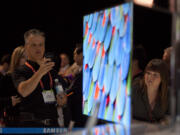 Industry affiliates examine the new Samsung 55-inch OLED television during the 2012 International Consumer Electronics Show on Jan.