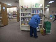 Dolly Jendro, of Washougal, looks over the new book selections Tuesday at the Vancouver Mall Community Library. The Fort Vancouver Regional Library District will reduce the space and services at the mall branch in 2013. &quot;It will have serious repercussions,&quot; Jendro, 81, said.