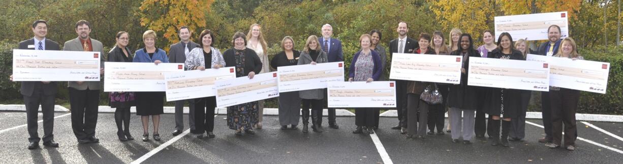 Andresen/St. Johns: Wells Fargo managers present $1,000 checks to Clark County school officials at a breakfast for elementary school principals on Nov.