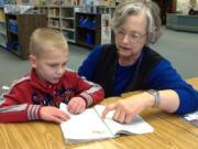 Yacolt: Yacolt Primary kindergartner Martell Hervi reads a book with Joan Spence, the school&#039;s media specialist, who applied for and received a $4,000 grant for the school&#039;s library from the Scholastic Reading Club and best-selling author James Patterson.