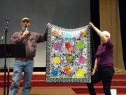 Esther Short: Fred Boyd and Janice Harding-Harris holding up one of the quilts for sale at the Clark County Quilters Auction, which raised $7,700 for the Children&#039;s Justice Center.