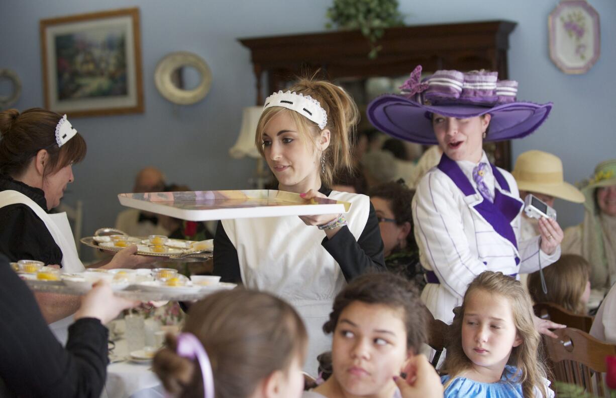 Samantha Feder, center, 17, of Vancouver wears an Edwardian-style maid's dress, apron and cap while serving &quot;passengers&quot; at the Titanic Tea.