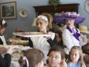 Samantha Feder, center, 17, of Vancouver wears an Edwardian-style maid's dress, apron and cap while serving &quot;passengers&quot; at the Titanic Tea.