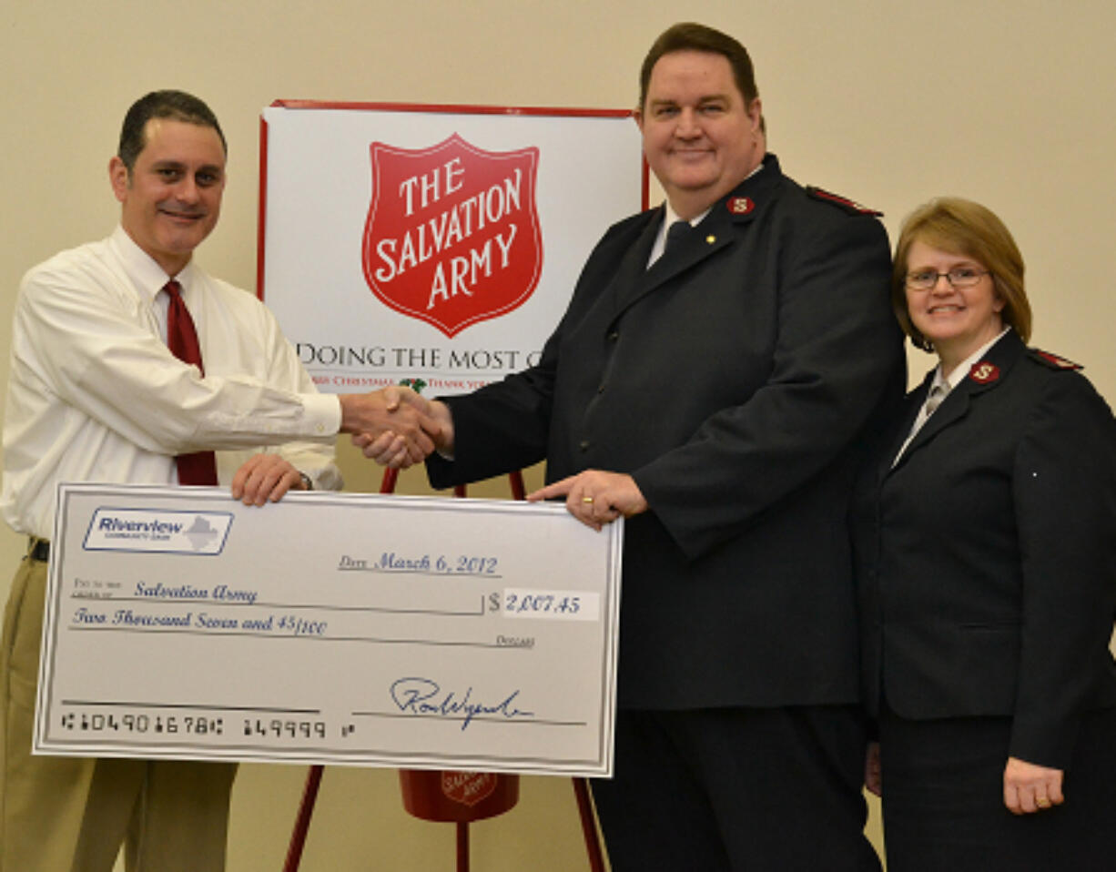 Fircrest: Sharif Burdzik of Riverview Community Bank, left, hands over some food money to Majors Ron &amp; Ronalee Fenrich of the Vancouver Salvation Army Corps.