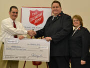 Fircrest: Sharif Burdzik of Riverview Community Bank, left, hands over some food money to Majors Ron &amp; Ronalee Fenrich of the Vancouver Salvation Army Corps.