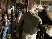 Members of Cub Scout Pack 443 from Battle Ground are impressed Wednesday afternoon as David Siddon and bald eagle Defiance enter Beaches Restaurant for an event leading up to Veterans Day observances.