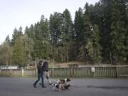 David and Summer Dunn, both 30, walk their dogs, back to front, Belle, Moose and Itchy, past a locked ball field at Abrams Park in Ridgefield.