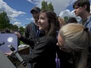 Michelle Pitel, 20, who is a student of Clark College astronomy and science teacher Dick Shamrell, holds a clipboard with an image of the sun projected onto it as Venus passes across the sun's face Tuesday.