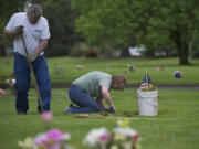 Warren and Sharron Wannmaker of the Burnt Bridge Creek neighborhood tend to the graves of Sharron's dad, Gene Lusby, grandfather and grandmother at Park Hill Cemetery on Sunday.