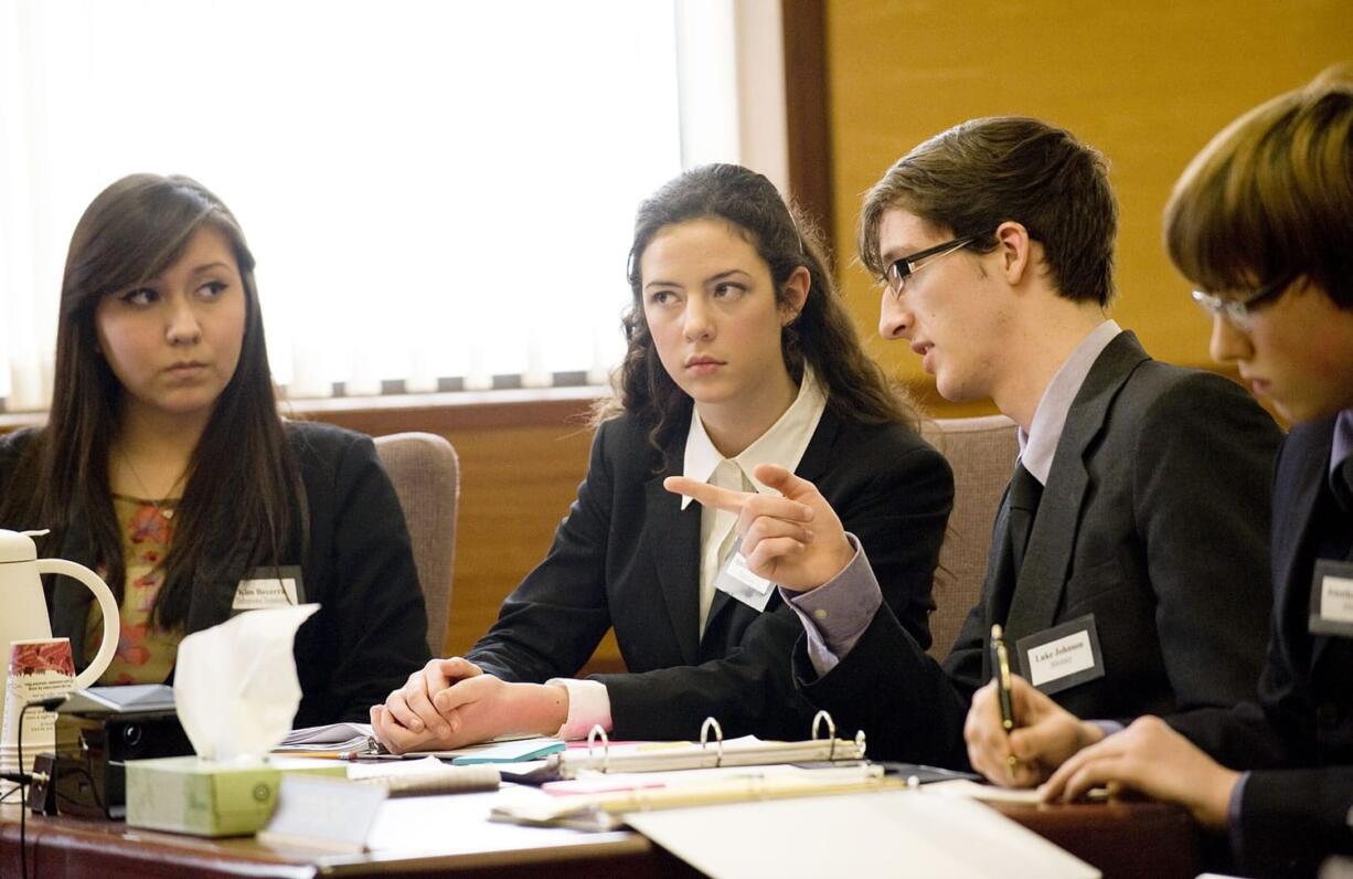 Photos by Steven Lane/The Columbian
Hudson's Bay High School defense team members, from left, Kimberly Becerra, Amber Finder, Luke Johnson and Jonathan Muck discuss their case during a mock trial Thursday afternoon at the Clark County Courthouse. Top: Superior Court Judge Robert Lewis listens to testimony Thursday.