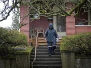 A mail carrier walks down steep steps after delivering mail to a home on West 21st Street in the Hough neighborhood.