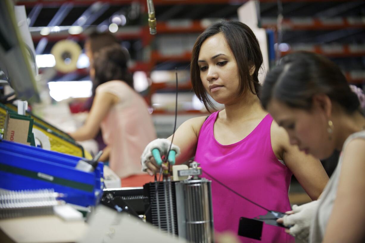 Vancouver-based Cadet Manufacturing's use of Washington state's shared-work program has enabled some of its workers, including Ros Sin, who assembles heating fans for the company, to keep their jobs in a tough economy.