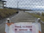 A man walks along a closed portion of the Renaissance Trail near the Tidewater Cove Condominiums on Tuesday.