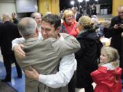 Vancouver city councilors Bart Hansen, right, and Larry Smith embrace after learning they had been re-elected Tuesday night.