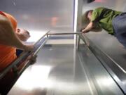 Jeremy Blakely, left, and Ryan Zaccheo, commercial glaziers for D&amp;L Glass, install a half-inch glass door at the new Cinetopia theater in Vancouver.