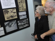 Luanne (Wolfe) Barnes, a survivor of the 1948 Vanport Flood, looks at old photos with her husband, Ed Barnes, at Saturday&#039;s opening of the Vanport Flood Exhibit at the Water Resources Education Center in Vancouver.