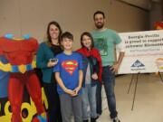 Lake Shore: Eisenhower Elementary School teacher Tricia Hoffarth, with her husband, Erick Hoffarth, and their two children, appear at a school assembly, in which she was honored with a teacher hero award from The Kids in Need Foundation.