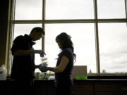 David Thompson, left, and Linda Pham are in a class at Clark College that's one of only three in the state to take part in a global effort to fight back a fungus that's wiping out wheat fields.