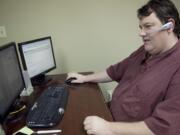 Christopher Kirk, a senior technology consultant, takes calls and answers customer questions.