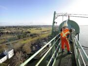 Oregon Department of Transportation bridge supervisor Marc Gross, foreground, and Ryan Cox, assistant supervisor, install a propane-powered air cannon on the Interstate Bridge on Thursday.