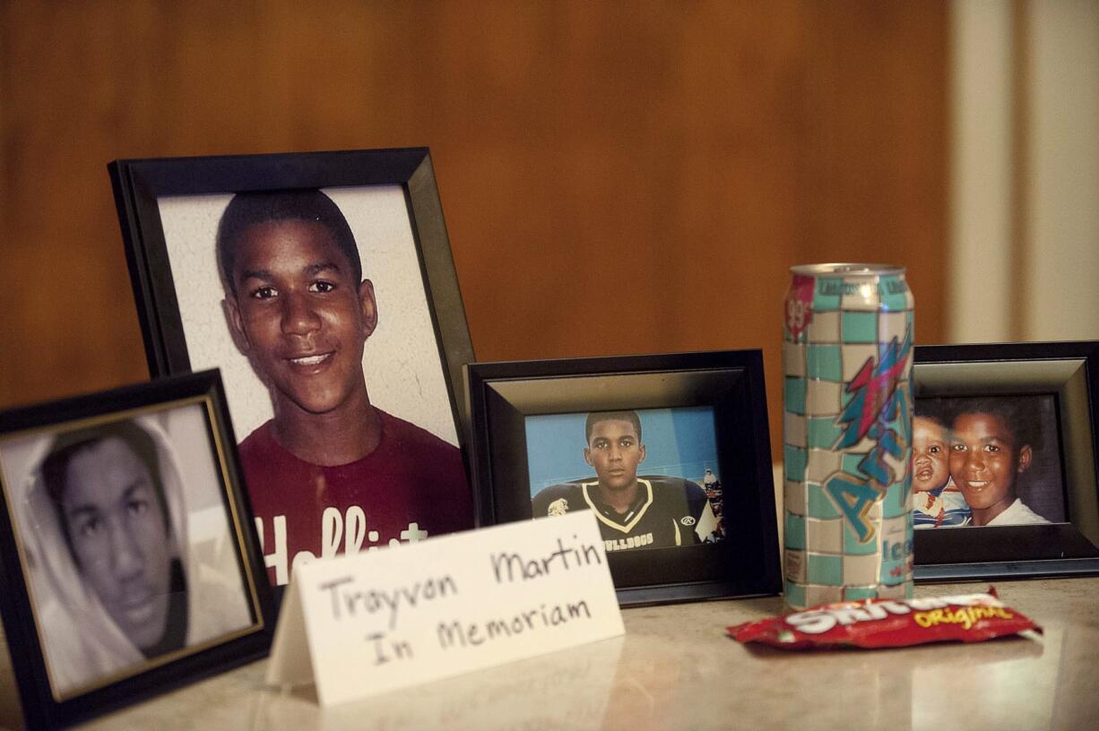 Zachary Kaufman/The Columbian
A bag of Skittles candy and a can of Arizona Ice Tea sit next to photographs of Trayvon Martin during a candlelight vigil at First Congregational United Church of Christ.