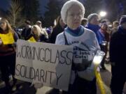 Jobs with Justice member Jane McAlonan, of Vancouver, stands in solidarity with workers from The Hilton Vancouver Washington during a candlelight vigil between the hotel and City Hall on Tuesday.