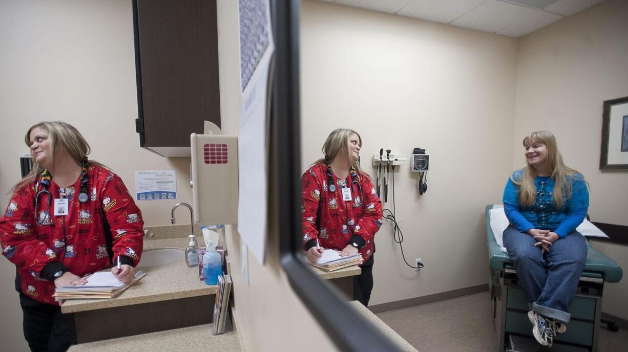 Photos by Zachary Kaufman/The Columbian
Medical assistant Lisa Wood, left, takes information from patient Barbara Kelly of Vancouver during a routine follow-up visit to Columbia River Occupational Health.