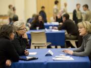 Vancouver City Councilor Jeanne Stewart, right, talks with Kim Vine, far left, and Dr. Cynthia Bye during a town hall meeting at Clark College Columbia Tech Center on Tuesday.