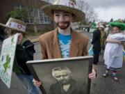 Kellen Larsen, 10, holds a portrait of Paddy Hough as he lines up with other fifth-graders from Mina Milligan's class at Hough Elementary before the start of Friday's annual parade.