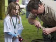 Steven Lane/The Columbian
Ken Sandusky, with the U.S. Forest Service, removes the hook from Kindell Frampton's first trout, which she caught in the fishing pond at the Get Outdoors Day event at the Fort Vancouver National Site on Saturday. The two fishing ponds were stocked with 800 trout.