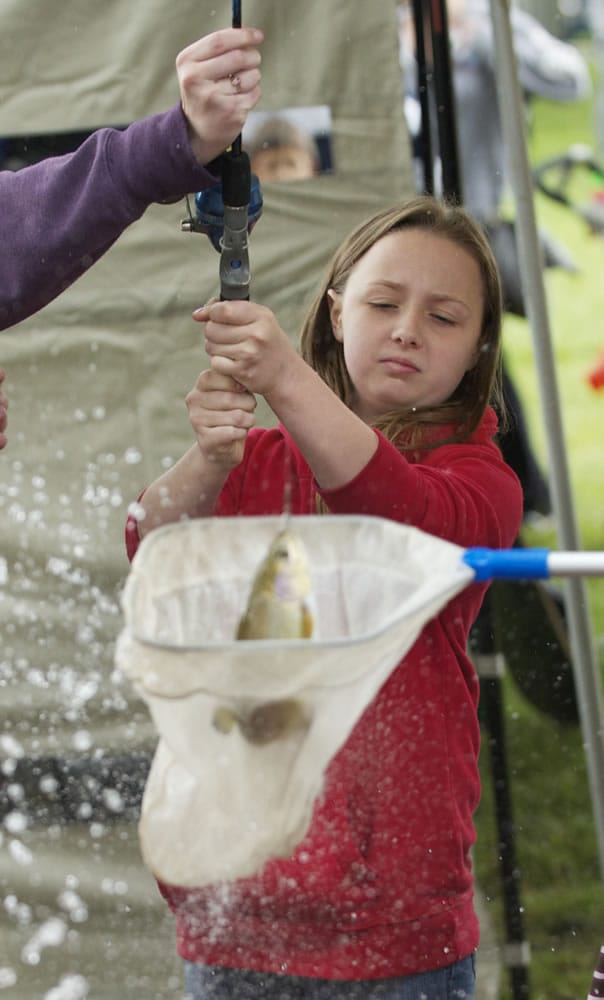 Steven Lane/The Columbian
Charlotte Frampton, 11, catches a trout from a fishing pond at the Get Outdoors Day event at the Fort Vancouver National Site on Saturday. The two fishing ponds were stocked with 800 trout.