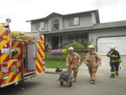 A firefighter wheels out a fan used Wednesday evening to ventilate the site of a fire at 5525 N.W.