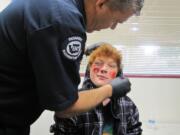 Fire District 6 EMS Capt. Mike Hollingsworth applies moulage makeup on Blake Black to simulate an injury at Vancouver's former city hall building on Thursday.