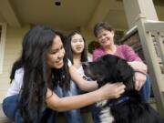 The Hickey family, from left, Sydney, 16, Olivia, 14, and Belinda, recently adopted Bella, a border collie mix that belonged to Steven Stanbary, who killed his wife and twin sister and then set fire to the house they shared in Washougal. Stanbary also died. Bella and two other dogs and a cat survived the fire and shootings.