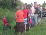 Family and friends gather to pay their  respects to Tatyana Tupikova Saturday night off S.W. 10th Avenue in Battle Ground, near where her body was found Friday.