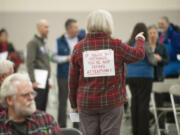 Edie Cotton wore a sign on her back opposing the proposed Vancouver Energy oil-by-rail terminal during a hearing at the Clark County Event Center at the Fairgrounds on Tuesday. The Energy Facility Site Evaluation Council is taking comment on the project until Jan. 22 as it finalizes an environmental review and prepares a recommendation for the governor.