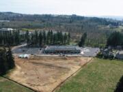 An aerial view of Fisher Investments' Camas campus shows the company's newly completed one-story building with its multistory office building in the background.