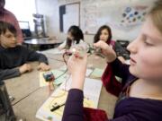 Hannah Callan, 10, a fifth-grader at Columbia Valley Elementary School, cranks her own electricity Tuesday.