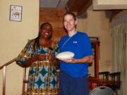 Dr. Jim Heid and a Rwandan woman preseneted a typical side dish made of corn flour and water to a family in Gisenyi.