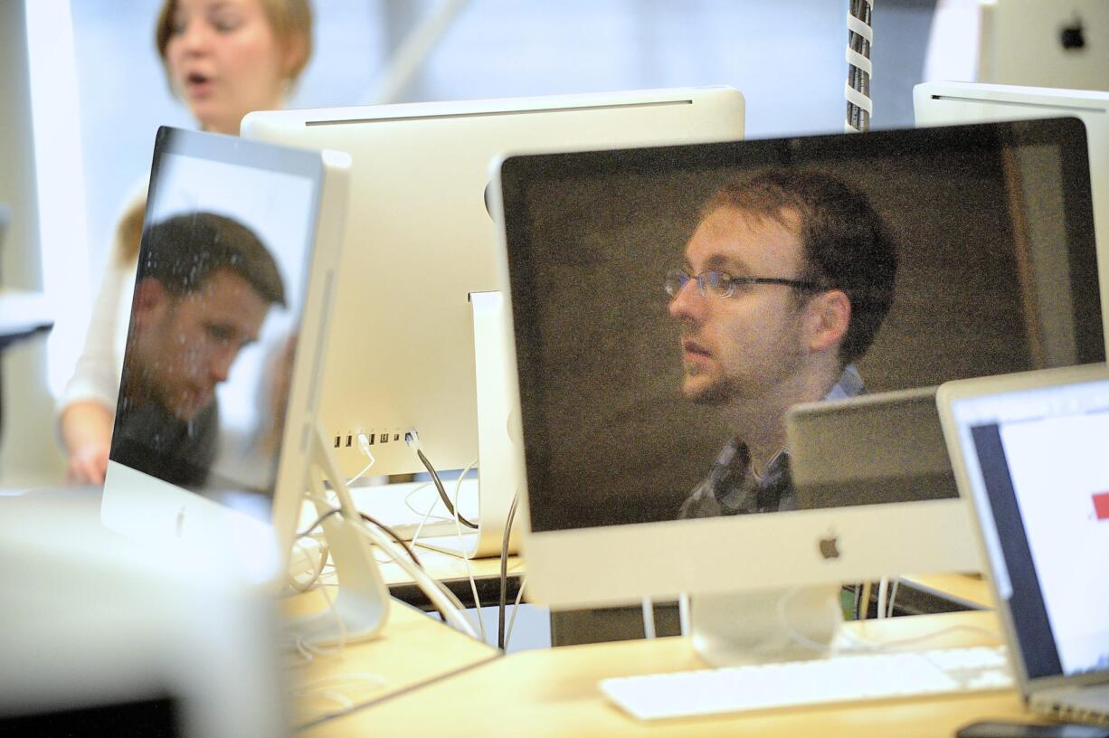 Chad McClure, a student at Washington State University Vancouver, reflected in monitor at right, will graduate from the Creative Media &amp; Digital Culture program in August and is working part-time in Web operations at Dick Hannah Dealerships in Vancouver.