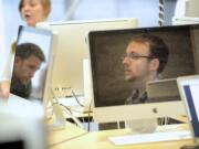 Chad McClure, a student at Washington State University Vancouver, reflected in monitor at right, will graduate from the Creative Media &amp; Digital Culture program in August and is working part-time in Web operations at Dick Hannah Dealerships in Vancouver.