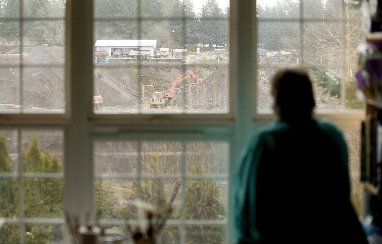 Renee Anttila looks out on the gravel quarry behind her First Place Neighborhood home on Tuesday. The quarry, owned by Tapani Underground, will be mined out by the end of the year and then reclaimed.