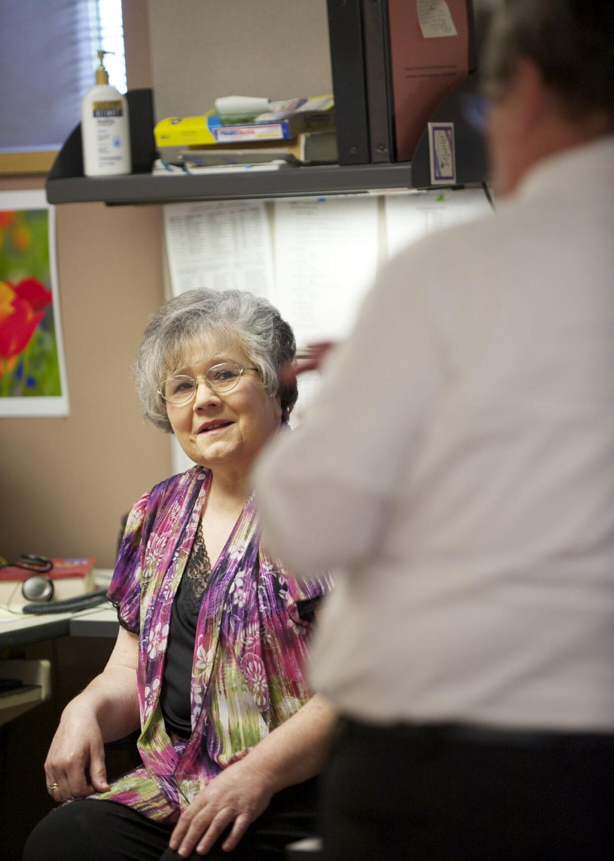 Steven Lane/The Columbian
Carole Axford, a secretary at the Clark County Prosecutor's Office, chats Wednesday with Deputy Prosecutor Michael Dodds. After 50 years, Axford is the longest-serving county employee in recent memory.