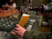 Angelo De Ieso II pours a bottle of Silver City Deluxe Spring Lager at By The Bottle's Taproom in downtown Vancouver.