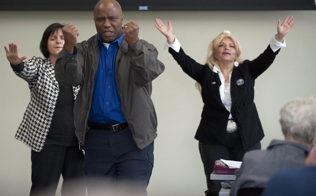 Rey Reynolds of Vancouver prays for the four corners of Clark County on Thursday at Vancouver City Hall.